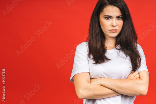 Young beautiful hispanic sad woman serious and concerned looking worried and thoughtful facial expression feeling depressed isolated over red background in sadness and sorrow emotion.