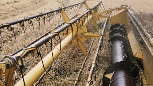 Detail of combine havester reel on rice fields, slow motion photo