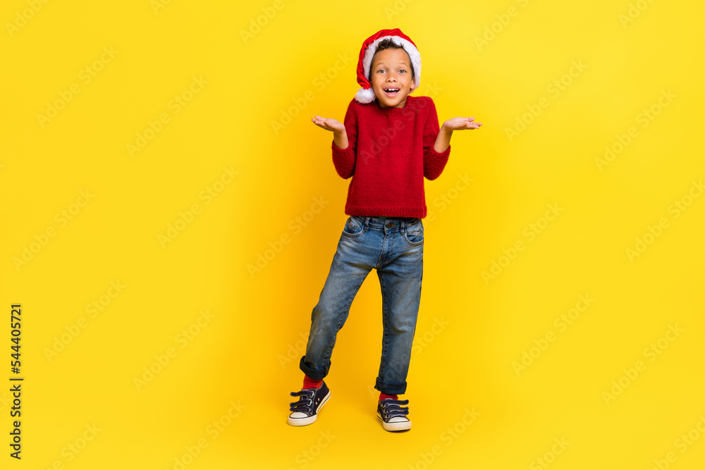 Fototapeta premium Full size photo of charming small boy shrug shoulders north pole dressed stylish red knitted clothes isolated on yellow color background