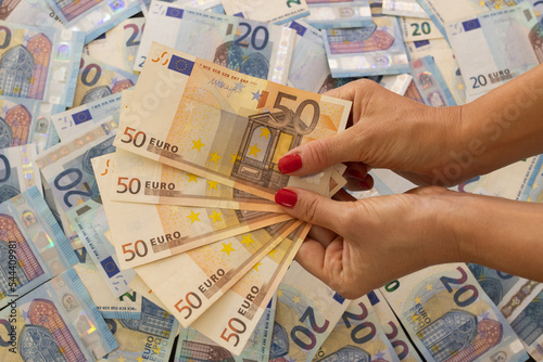 Female hands holding bunch of euro money banknotes cash in 20, 50 € photo