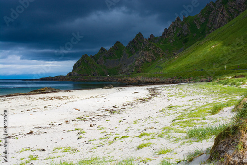 White sandy Bleik beach against dark stormy clouds on the Andøya island in Norway photo