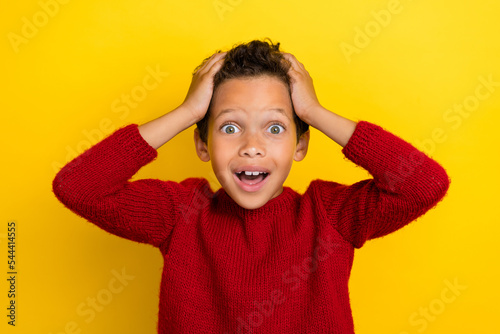 Photo portrait of cute small schoolboy touch head cant believe lucky dressed stylish red knitted look isolated on yellow color background