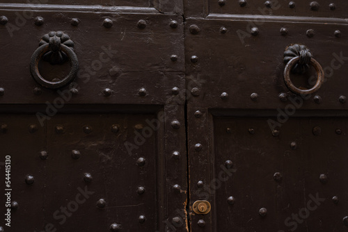 Old wooden door with two doorknocker  photo