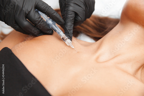 The cosmetologist makes anti-aging injections against wrinkles on the neck and in the decollete area. Women's cosmetology.