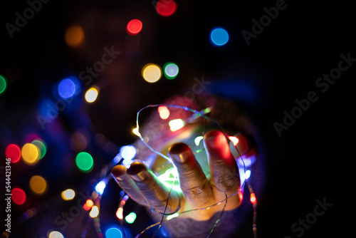 Girl's hand holding christmas lights at night