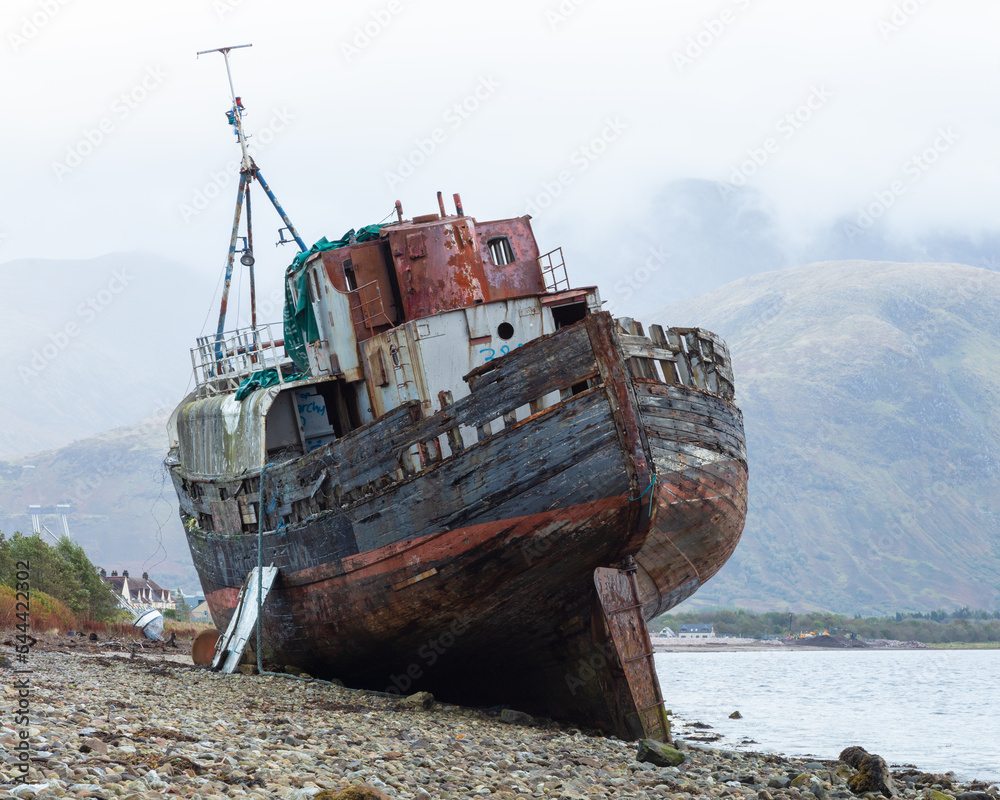 The Corpach Wreck.  A wrecked and abandoned trawler on the banks of Loch Eil, North West Scotland with Ben Nevis Mountain in the background.