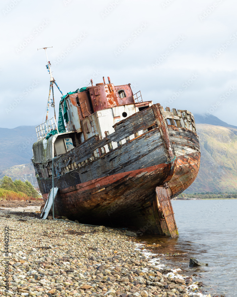 The Corpach Wreck.  A wrecked and abandoned trawler on the banks of Loch Eil, North West Scotland with Ben Nevis Mountain in the background.