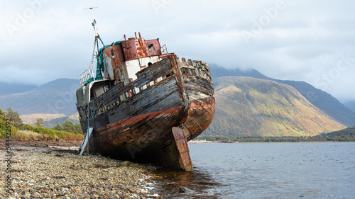 The Corpach Wreck.  A wrecked and abandoned trawler on the banks of Loch Eil, North West Scotland with Ben Nevis Mountain in the background. photo