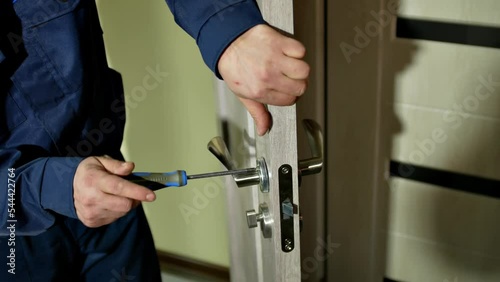 repair or construction in the premises
installation and repair of interior doors
the worker screws the door handle with a screwdriver
professional skills in performing repair and installation work