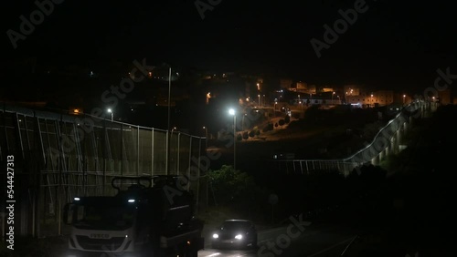 The fence of the city of Melilla, Spain, in the dark night borders Morocco, Africa.