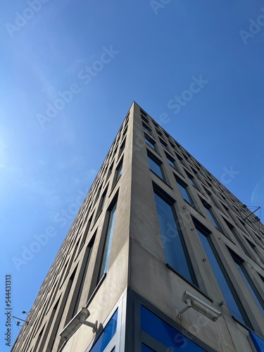 the corner of the building with large windows on the background of the sky