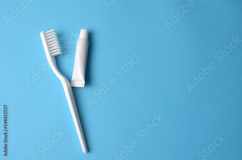 Toothbrush tube of toothpaste on a blue background.