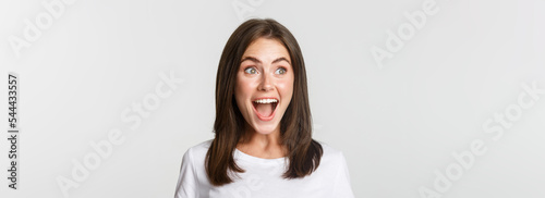Fényképezés Portrait of joyful pretty brunette girl looking left amused, smiling excited and