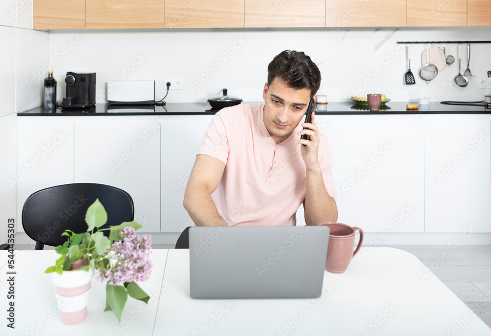 Young businessman working on laptop and drinking tea at home. Distant work concept Young businessman working on laptop and drinking tea at home. Distant work concept