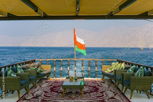 Oman Flag on a boat with sea and mountain backgrounds  photo