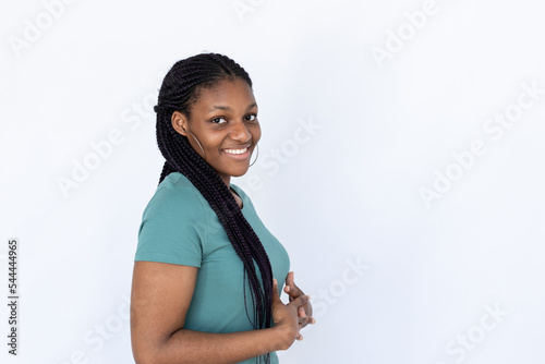 Satisfied woman with hands together. Young female model in turquoise T-shirt holding hands together looking at camera. Portrait, studio shot, advertising concept