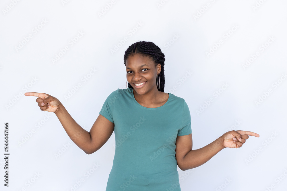 Happy woman pointing at opposite sides. Young female model in turquoise T-shirt pointing into different directions. Portrait, studio shot, advertising concept Happy woman pointing at opposite sides. Young female model in turquoise T-shirt pointing into different directions. Portrait, studio shot, advertising concept