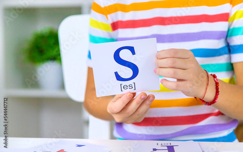 The child learns English letters. Selective focus. photo