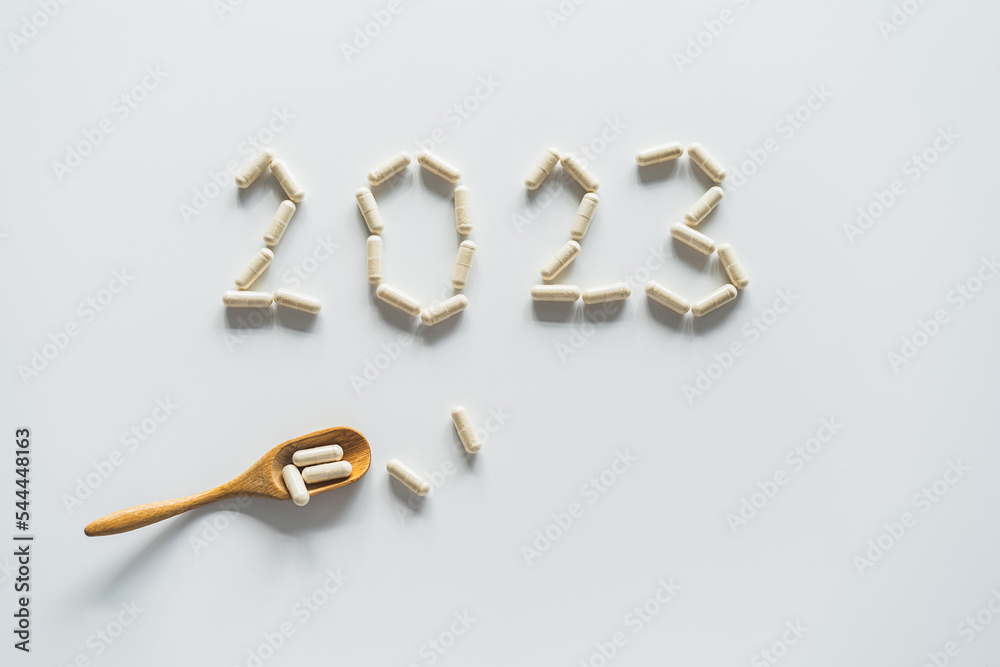 Vitamins on a white background. White Capsules form the new year 2023. Concept of health and new year.