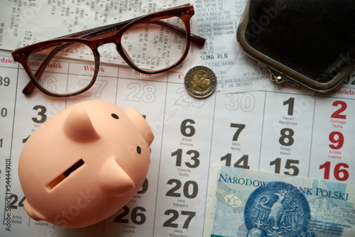 paragony fiskalne ,polskie banknoty , polska moneta, kartka z kalendarza, świnka skarbonka, emerytura 