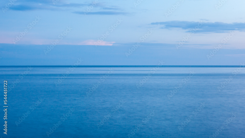 Background from the blue sea and sky with clouds and horizont line in the middle. Blue seascape for publication, poster, screensaver, wallpaper, postcard, cover, post. High quality photo