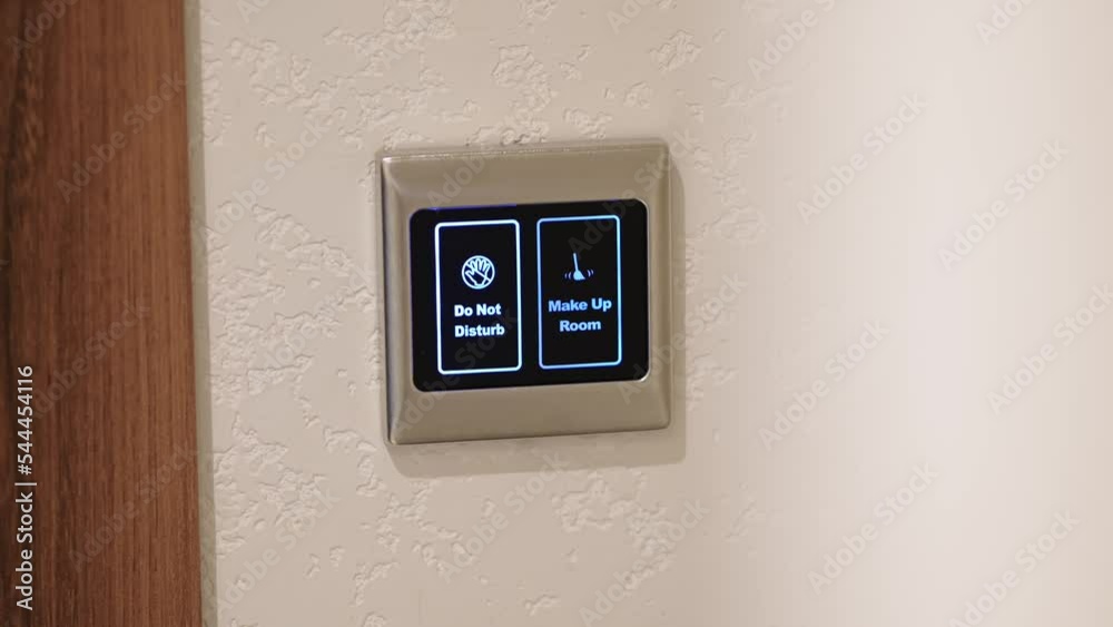 Close-up of a woman pressing a button on a display that says do not disturb. Electronic do not disturb sign on the door in a modern hotel Close-up of a woman pressing a button on a display that says do not disturb. Electronic do not disturb sign on the door in a modern hotel