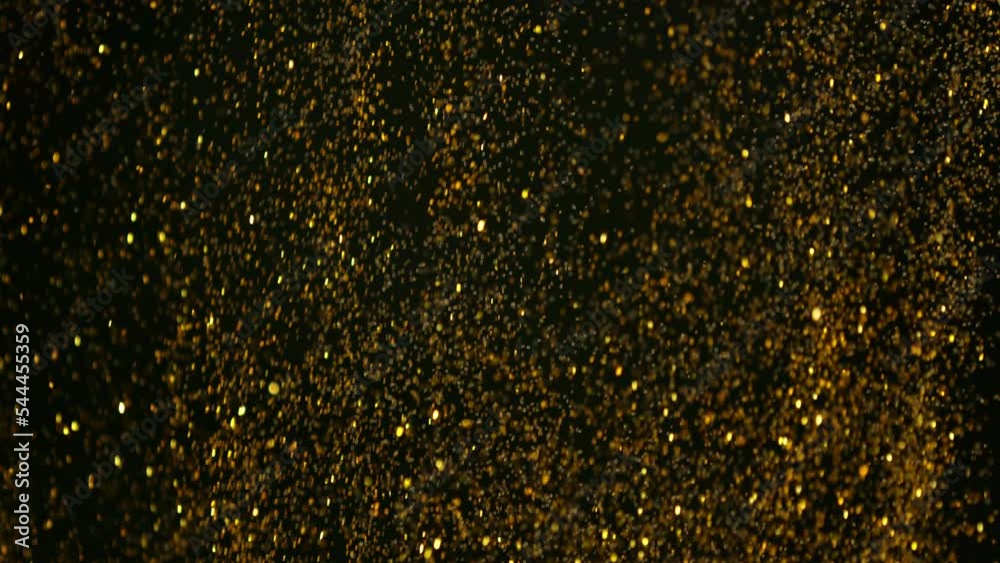 Super slow motion of glittering golden particles. Isolated on black background. Shallow depth of focus. Filmed on high speed cinema camera, 1000 fps. Super slow motion of glittering golden particles. Isolated on black background. Shallow depth of focus. Filmed on high speed cinema camera, 1000 fps.