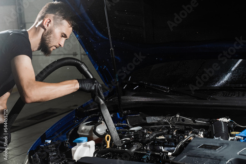 Process of drying car engine after washing with water and chemical detergent. Detailing cleaning motor from dust and dirt.