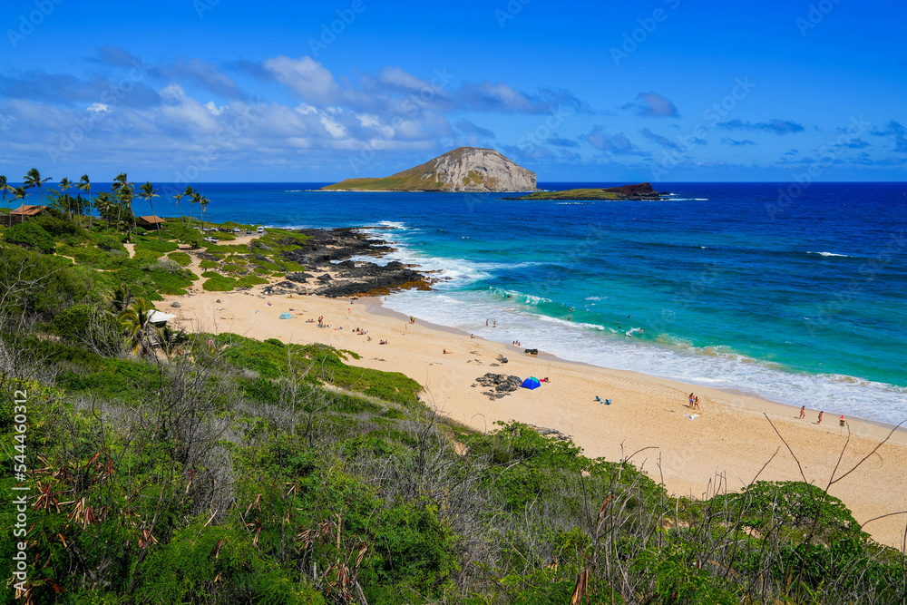 Beautiful white sand beach and translucent waters with a view over Manana Island and Kaohikaipu Islet seabird sanctuaries in Makapu'u Beach Park on the eastern side of Oahu island in Hawaii, USA