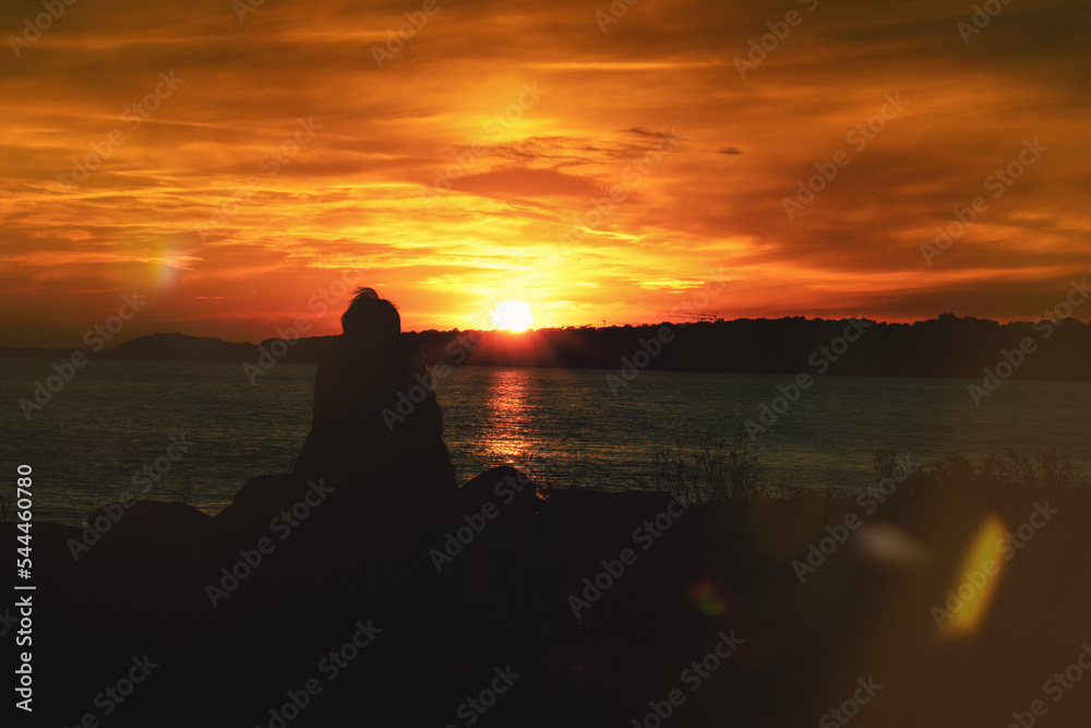 Frau am Meer im Sonnenuntergang