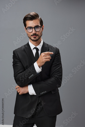 Man businessman in business suit and eyeglasses with brunette beard on gray background. The concept of good business and expensive clothes a copy space