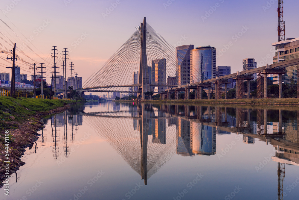 Fototapeta premium View of Pinheiros River With Modern Buildings Alongside and Famous Octavio Frias de Oliveira Bridge in Sao Paulo City