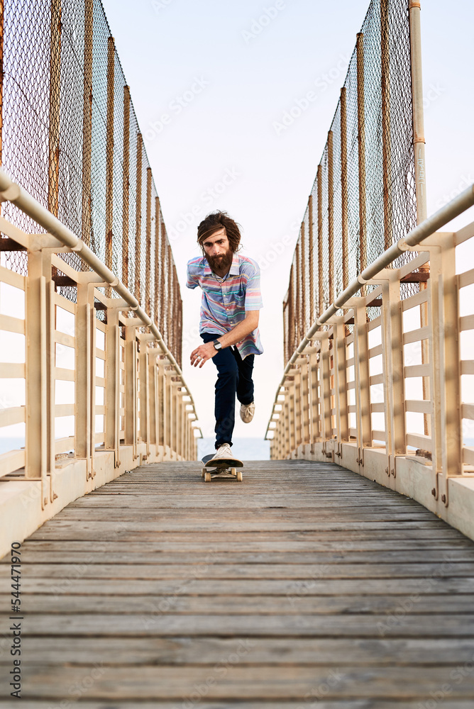 Bearded skater riding on wooden bridge