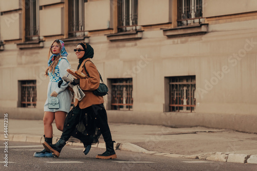 A modern European woman and a Muslim woman with a hijab walking the streets of the city dressed in clothes from the 19th century while carrying newspapers, flowers and bread in their hands.