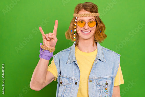 Photo of youngster guy make horned symbol enjoy concert wear stylish trendy jeans vest isolated vibrant color background