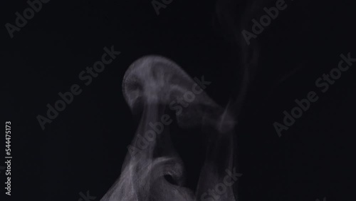 White steam smoke vapor coming up from a hot coffee cup in extreme close-up, authentic nature steam smoke, mist on a black background, shot in 4K. Concept of steam, smoke, vapor, mist, fog