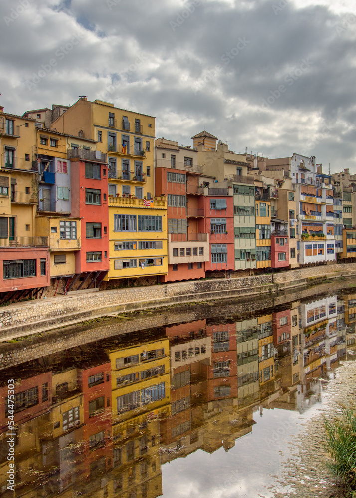 A view of Girona's colourful riverside buildings reflected in the River Onya