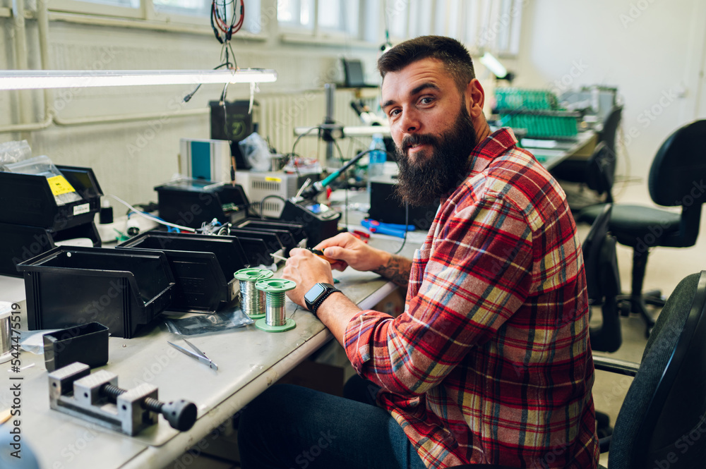 Electronics engineer working in a workshop with tin soldering parts Electronics engineer working in a workshop with tin soldering parts