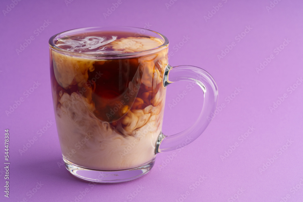 Transparent cup of coffee with cream forming a beautiful pattern. Space for text Transparent cup of coffee with cream forming a beautiful pattern. Space for text