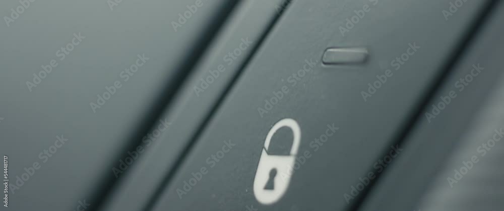 Woman’s finger press lock button female drives car safety in close up Woman’s finger press lock button female drives car safety in close up