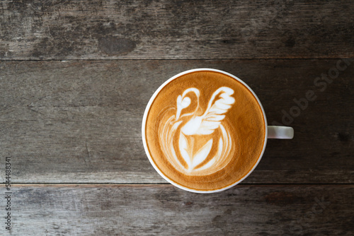 Fototapeta Naklejka Na Ścianę i Meble -  Latte art coffee with swan shape in coffee cup on wooden background, Hot drink, Table top view