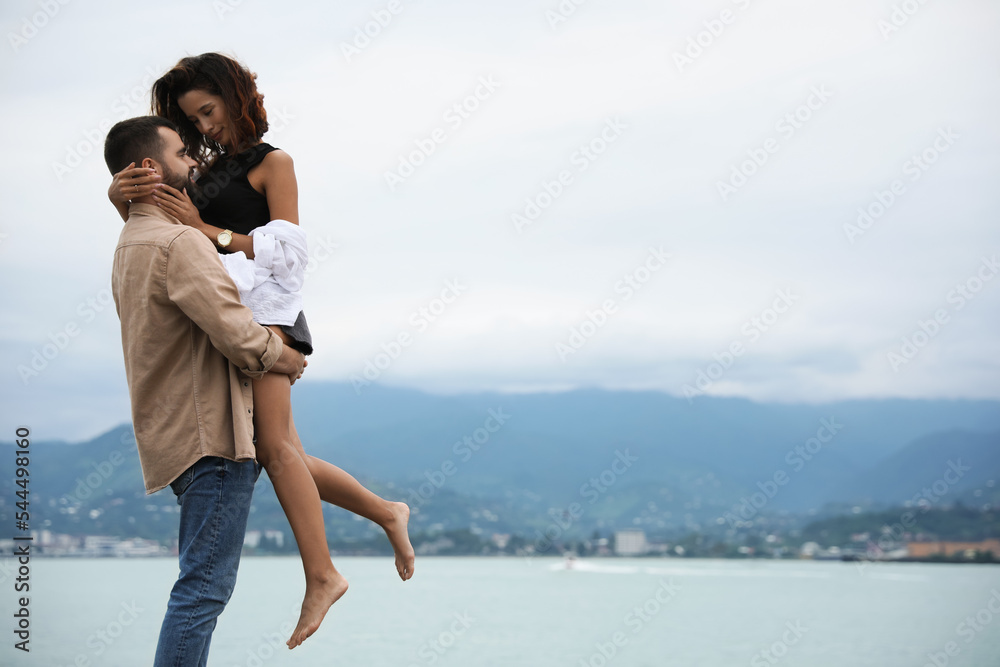 Beautiful young couple enjoying time together on beach, space for text Beautiful young couple enjoying time together on beach, space for text