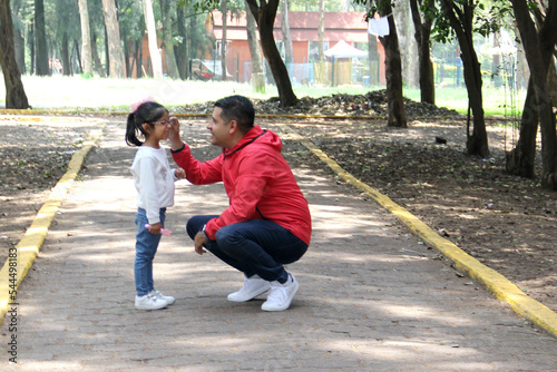Latino divorced single dad and daughter walk in the park and spend quality time with physical activity, talk without using technology