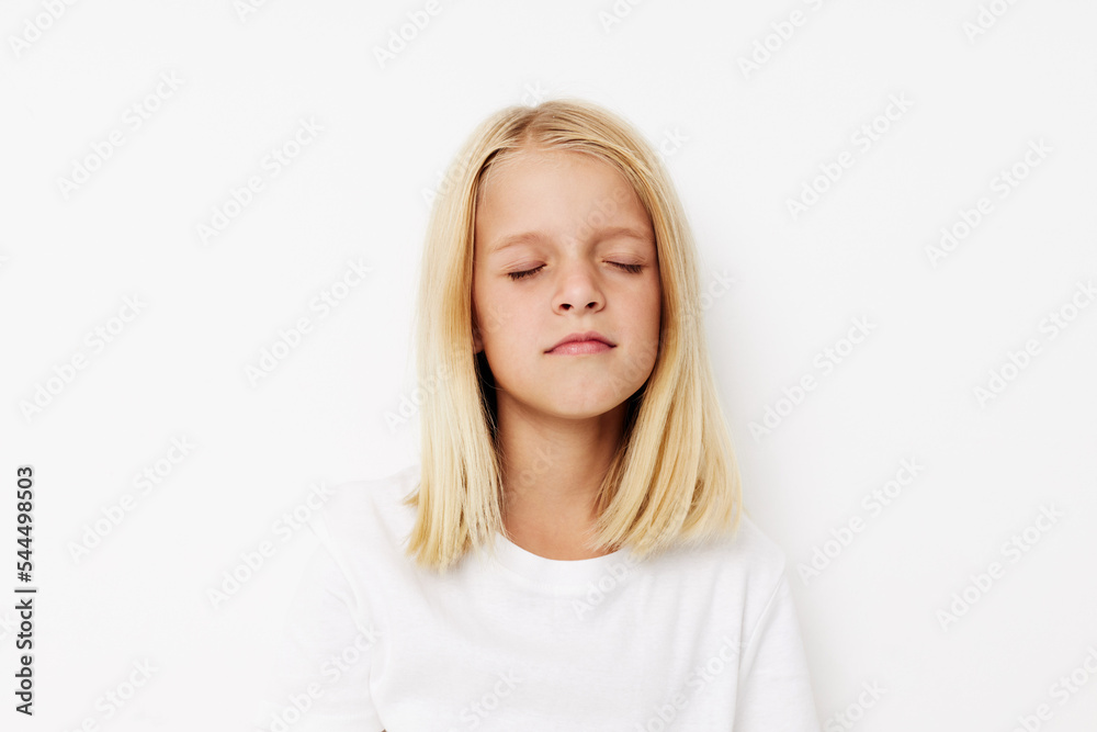 Beautiful little girl in a white t-shirt grimace on a light background Beautiful little girl in a white t-shirt grimace on a light background
