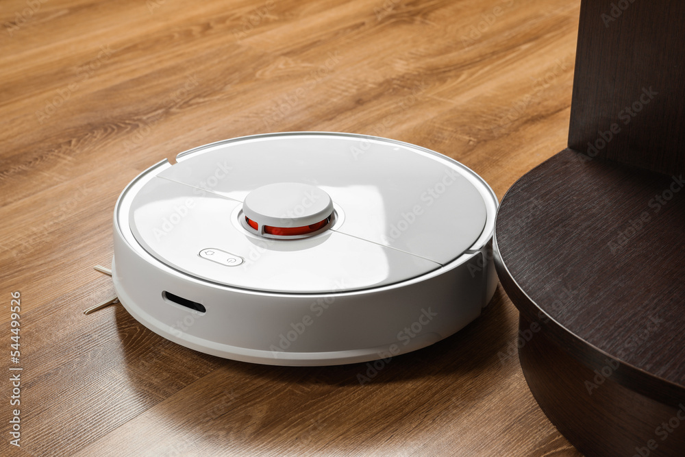 Robotic vacuum cleaner on wooden floor indoors Robotic vacuum cleaner on wooden floor indoors