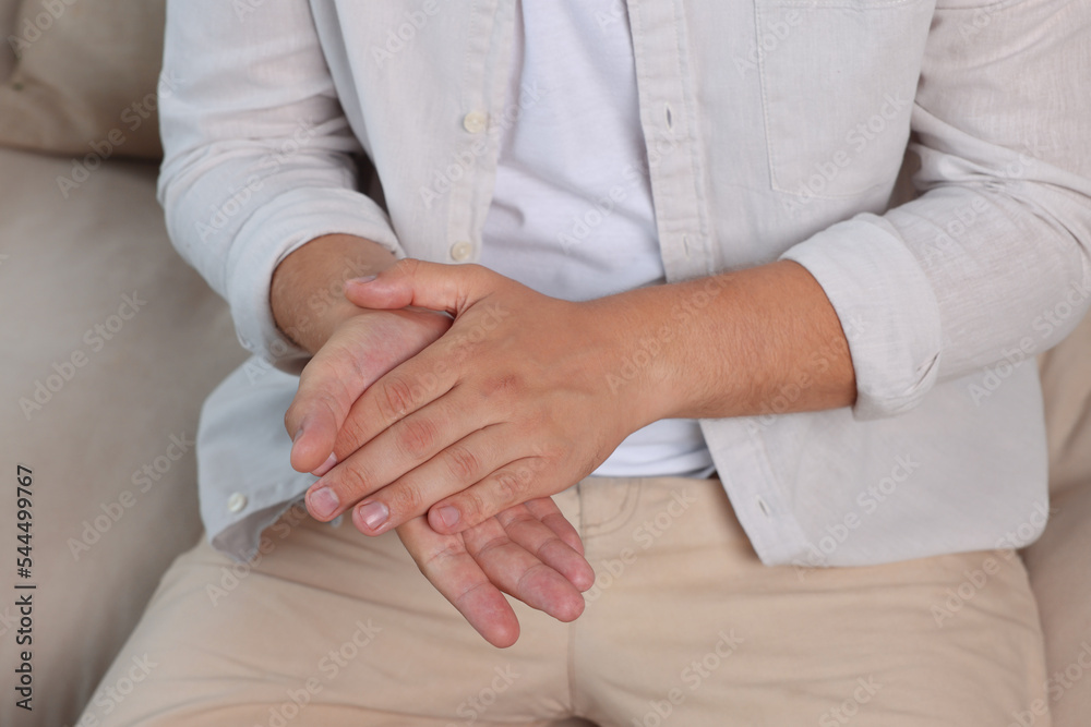 Man applying hand cream at home, closeup Man applying hand cream at home, closeup
