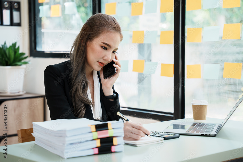 Asian businesswoman in formal suit in office happy and cheerful during using smartphone and working. Asian businesswoman in formal suit in office happy and cheerful during using smartphone and working.