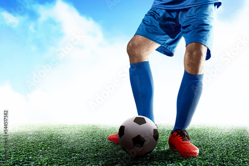 Fototapeta Naklejka Na Ścianę i Meble -  Football player man in a blue jersey kicking the ball
