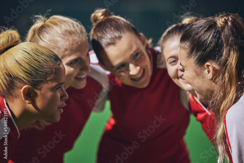 Women, football and team huddle on field at soccer game, motivation and team building for girl sports. Fitness, training and happy girls talk at soccer match in support of winning teamwork and goals.