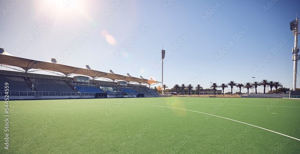 Empty sport field, outdoor grass and training stadium ground in summer ready for sports. Lawn care, sunshine and blue sky by a exercise, workout and game venue isolated and remote for fitness